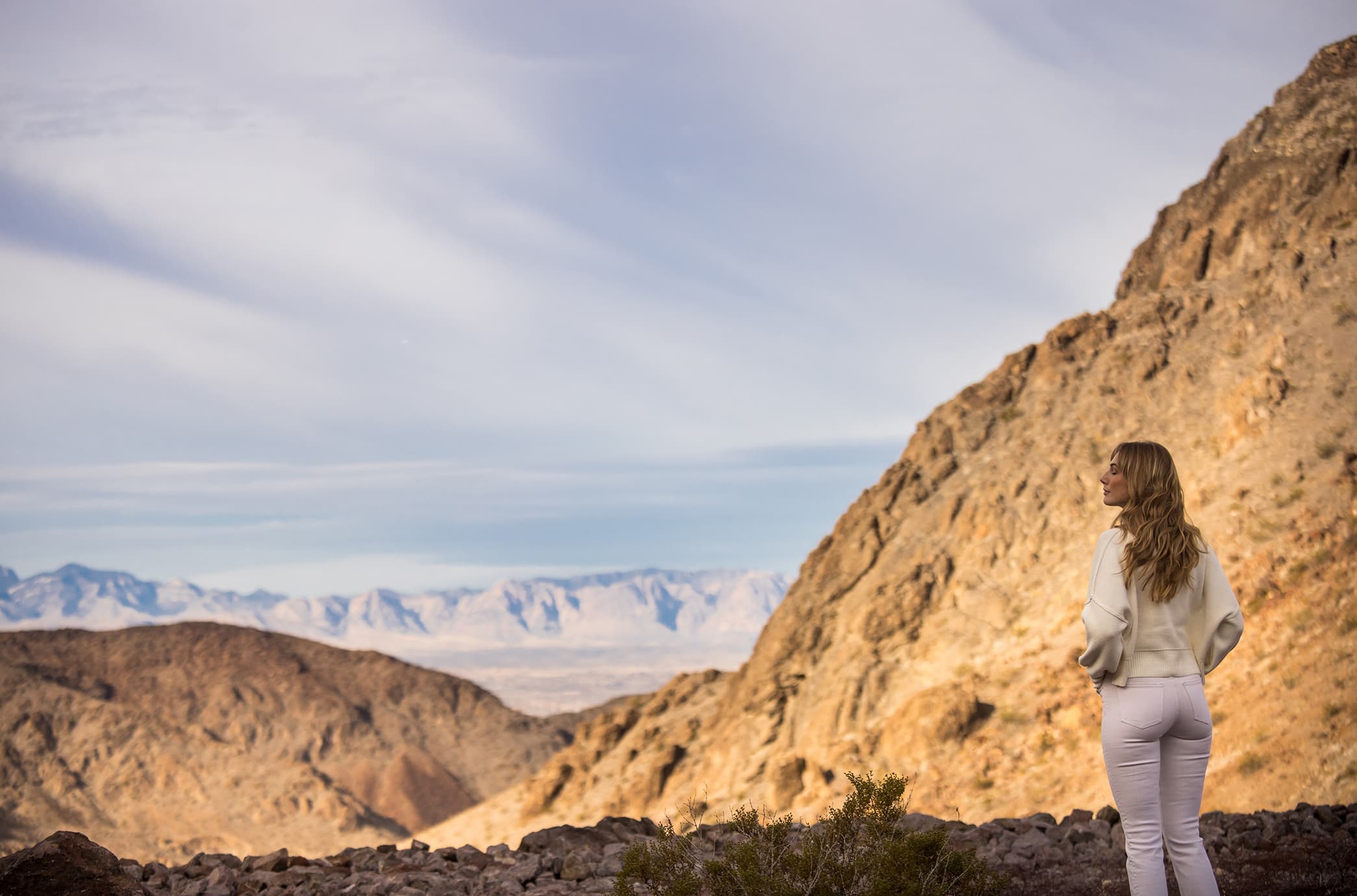 A resident taking in expansive desert and mountain views, standing along a scenic ridge with the dramatic landscape stretching into the distance.